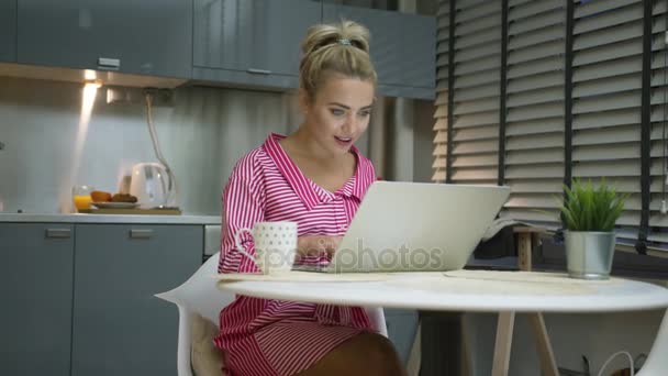 Donna eccitata utilizzando il computer portatile in cucina — Video Stock