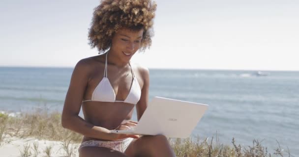 Красивая девушка с ноутбуком на пляже — стоковое видео