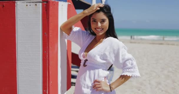 Расслабляющая молодая женщина на пляже в солнечном свете — стоковое видео