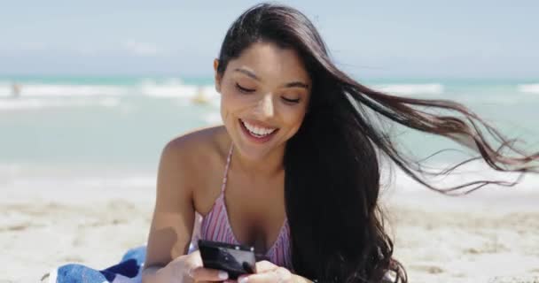 Schöne Frau mit Smartphone am Strand zufrieden — Stockvideo