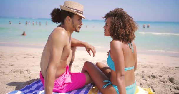 Pareja descansando en la playa en el océano — Vídeos de Stock