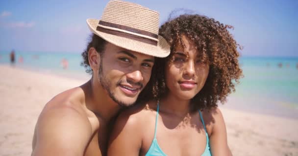Paar blickt am Strand auf Kamera — Stockvideo