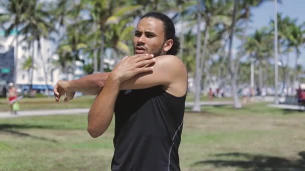 Hombre en forma étnica calentando brazo — Vídeos de Stock