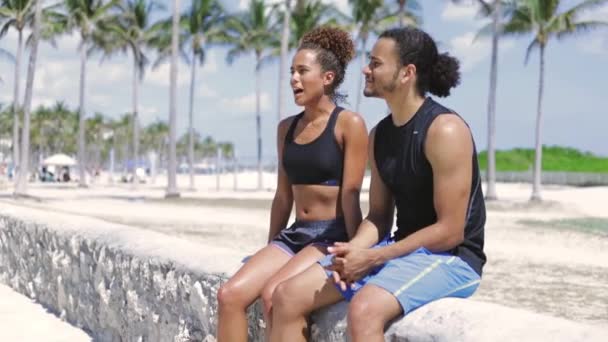 Etnické sportovní pár odpočívá — Stock video