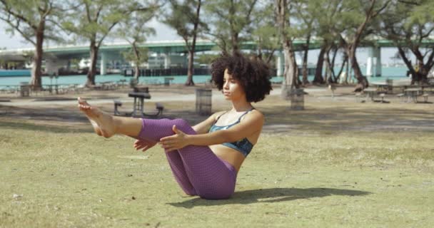 Flicka tränar buken muskler på äng — Stockvideo