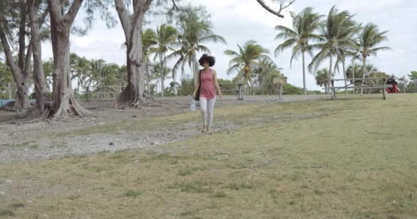 Meisje in park wandelen en zwaaien met de hand — Stockvideo