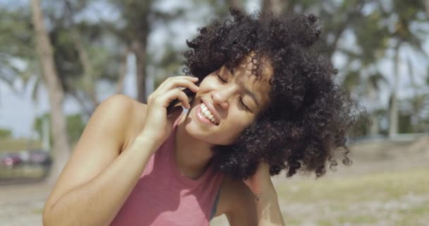 Bájos fekete lány beszél a telefonon, a napfény — Stock videók