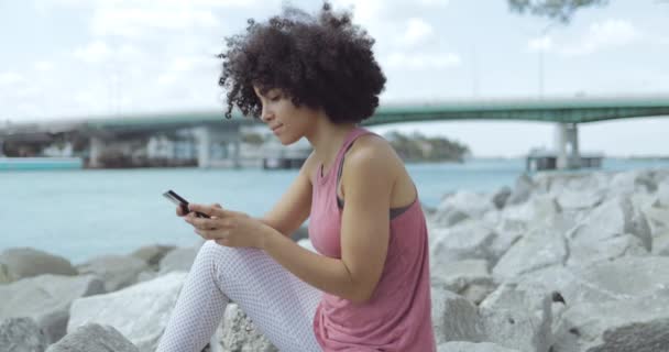 Mujer joven casual usando el teléfono en el terraplén — Vídeos de Stock