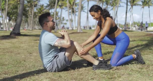 Femme aidant l'homme avec l'exercice dans le parc — Video