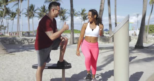 Chica alegre entrenamiento con instructor en la playa — Vídeos de Stock