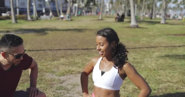 Homem ajudando mulher com exercício no parque — Vídeo de Stock