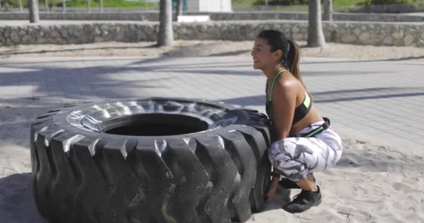 Femme essayant de soulever le pneu — Video