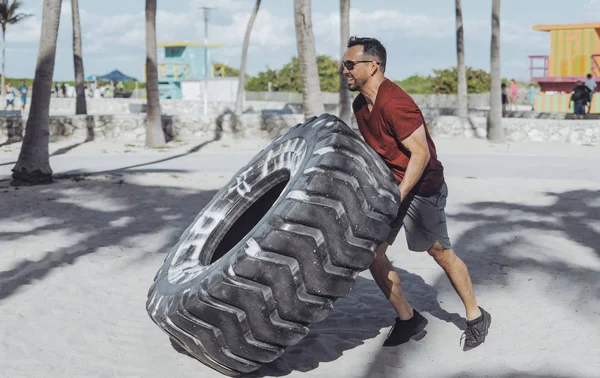 Homme travaillant avec un pneu — Photo