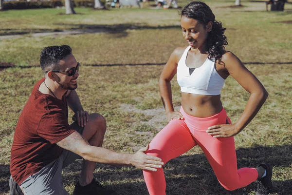 男子帮助妇女在公园锻炼 — 图库照片
