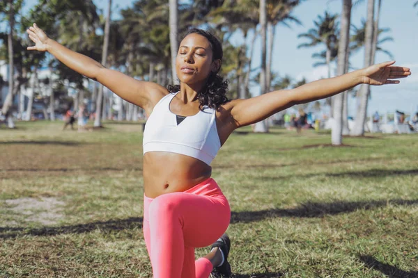 Relaxed black woman doing exercise in park — Stock Photo, Image