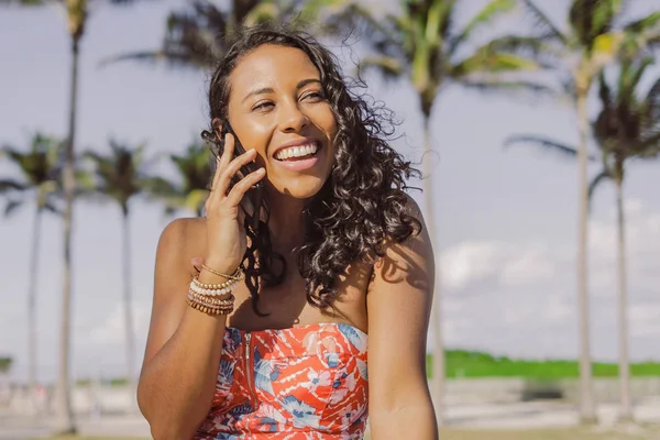 Vrij etnische vrouw praten over smartphone in de zomer — Stockfoto