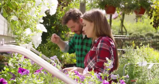 Gente contenta manteniendo flores en el jardín — Vídeos de Stock