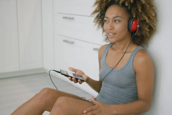 Jonge vrouw met hoofdtelefoon in keuken — Stockfoto