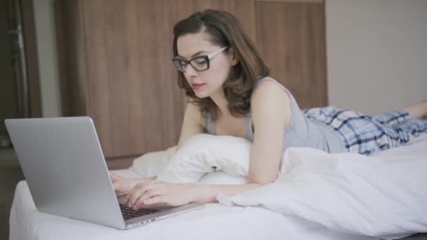 Kadın pijama dizüstü bilgisayar kullanarak — Stok video