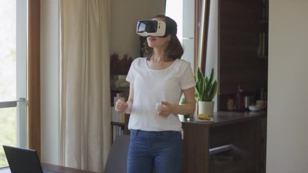 Vr のヘッドセットで自宅で立っている若い女性 — ストック動画