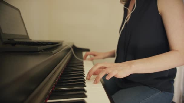 Mujer tocando el piano usando laptop — Vídeo de stock