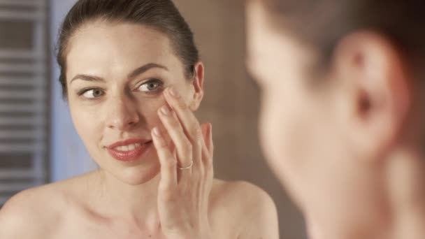 Mujer aplicando crema cerca de los ojos — Vídeos de Stock