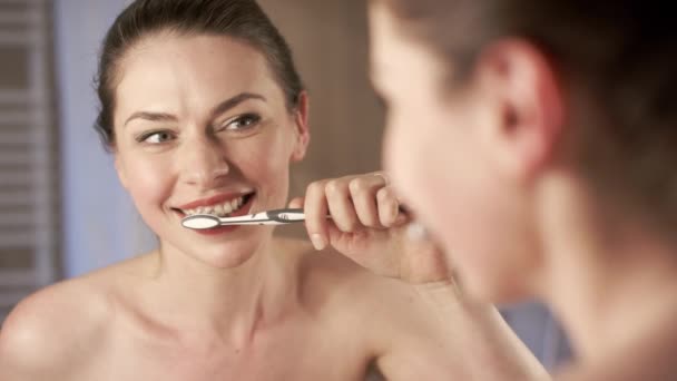 Jonge vrouw glimlachend en tanden poetsen — Stockvideo