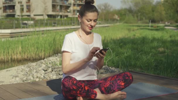 Jovem mulher ouvindo música em fones de ouvido — Vídeo de Stock