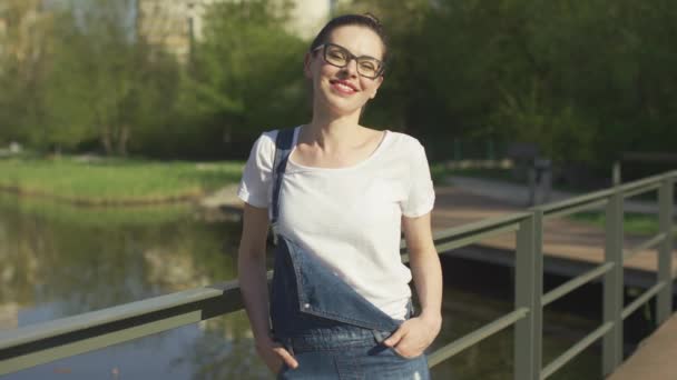 Donna sorridente appoggiata sul corrimano sopra l'acqua — Video Stock