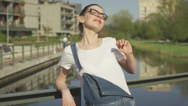 Lachende vrouw leunend op leuning boven water — Stockvideo