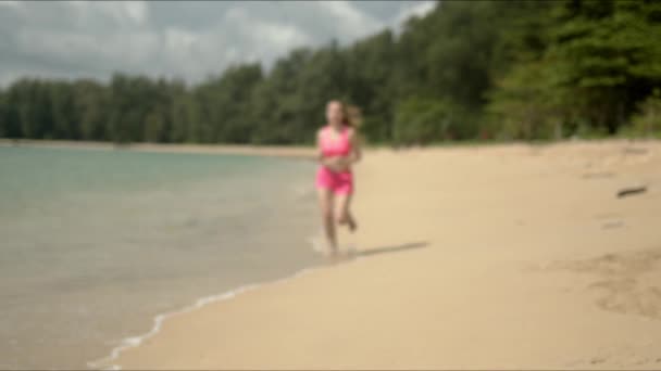 Mujer agradable en traje de baño rosa corriendo en la playa — Vídeo de stock