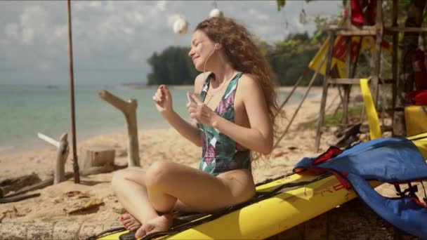 Mulher relaxada desfrutando de música na praia tropical — Vídeo de Stock