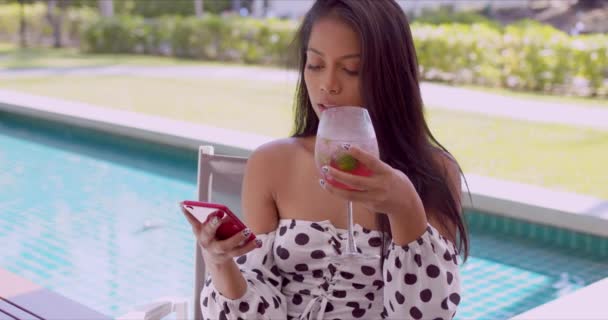 Glädjande etnisk ung kvinna interagerar med smartphone vid poolen — Stockvideo