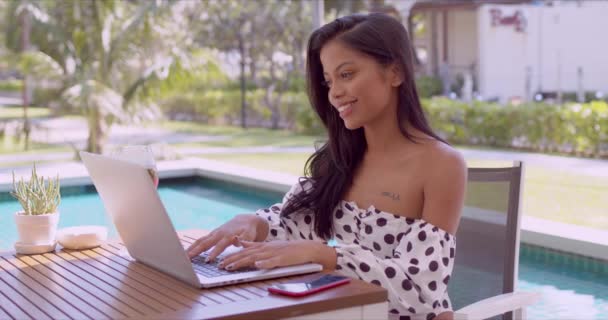 Счастливая молодая женщина с ноутбуком рядом с бассейном — стоковое видео