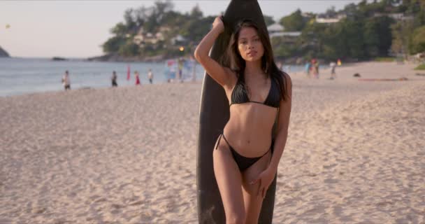 Fiatal nő szörfdeszkával töltött nap a tengerparton — Stock videók