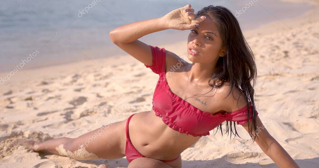 Morena sensual en traje de bano mojado tumbada en la arena Foto de stock dashek 317766632