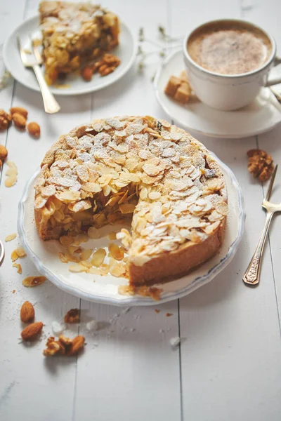 Deliciosa tarta de manzana entera con almendras servidas sobre mesa de madera —  Fotos de Stock