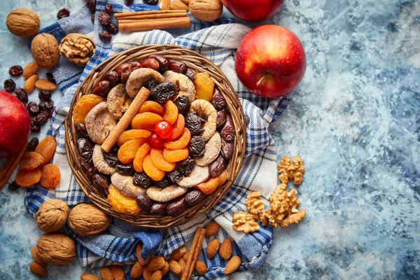 Composition des fruits secs et des noix dans un petit bol en osier placé sur une table en pierre — Photo