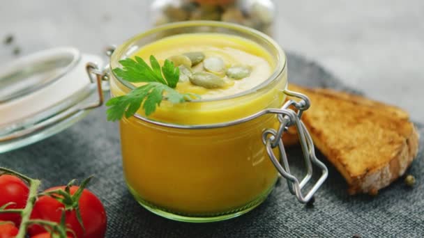 Soupe de citrouille crémeuse dans un bocal avec du pain et des tomates — Video