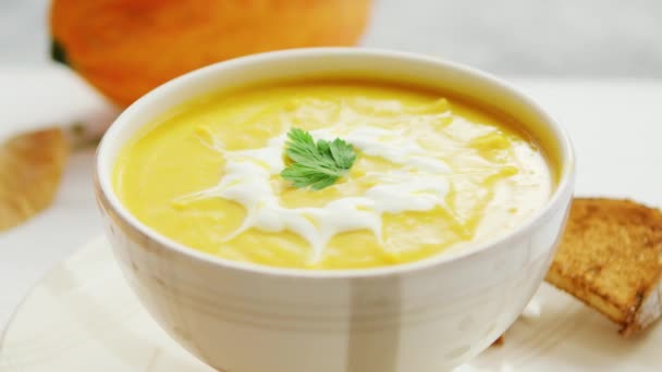 Pumpkin soup in bowl served with bread — Stock Video