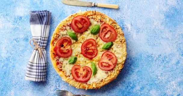 Deliciosa pizza italiana servida sobre una mesa de piedra azul, disparada desde arriba — Vídeos de Stock