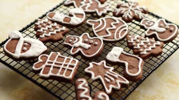 Fresh baked Christmas shaped gingerbread cookies placed on steel grill — Stock Video