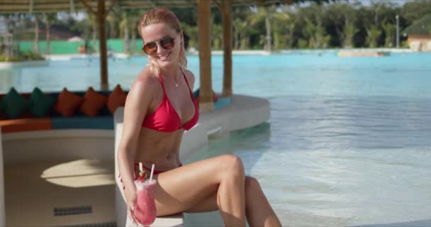 Šťastná žena s koktejlem odpočívající u bazénu — Stock video