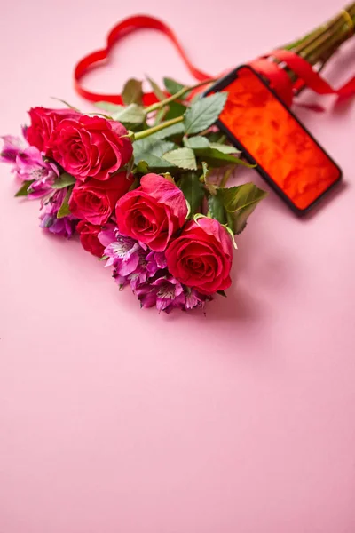粉红玫瑰花束与哈特形弓和手机与复制空间屏幕 — 图库照片
