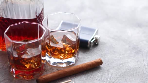 Два стакана старого виски с кубинской сигарой и графином — стоковое видео