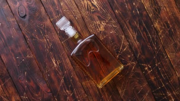 Бутылка виски на деревянном столе — стоковое видео