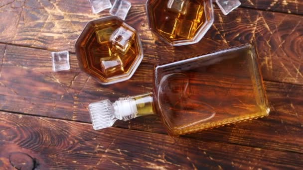 Fles whisky met twee glazen geplaatst op rustieke houten tafel — Stockvideo