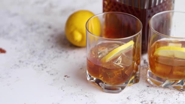 Whiskey saures Getränk mit Zitrone im Glas auf rustikalem Stein Hintergrund — Stockvideo