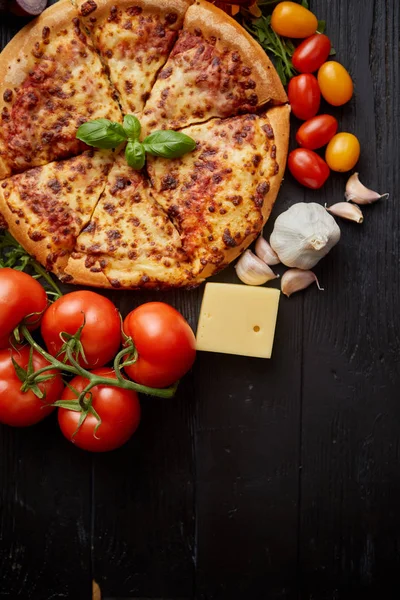 Läcker italiensk pizza serveras på svart träbord — Stockfoto