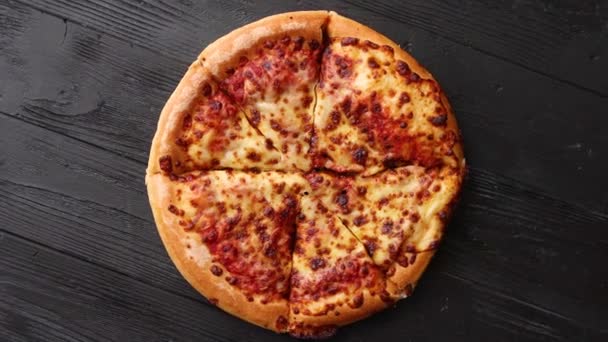 Піца пухнастого пепероні в американському стилі розміщена на іржавому старому чорному дерев'яному столі. — стокове відео